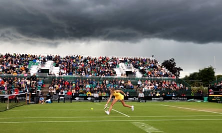 Karolina Pliskova plays a backhand against Ons Jabeur with a backdrop of dark clouds.