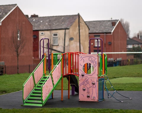 A children's play area next to terraced homes in Manchester, England