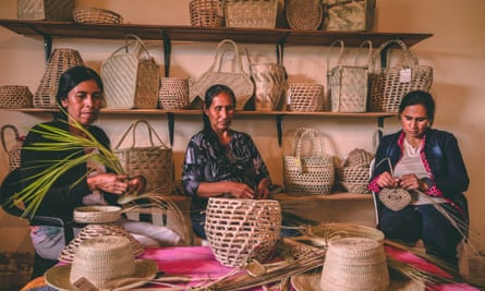 Indigenous Qom people weave baskets with palm leaves