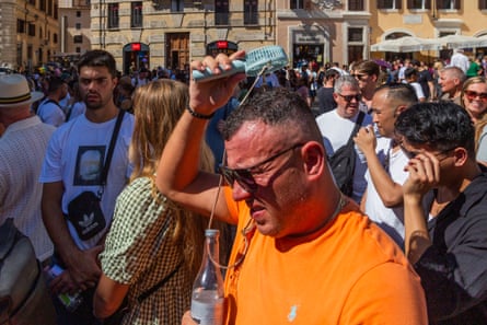A tourist shields himself from the heat in Piazza Navona during peak visiting hours