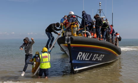 A group of about 40 migrants arrive via the RNLI  on Dungeness beach in Kent in August 2021