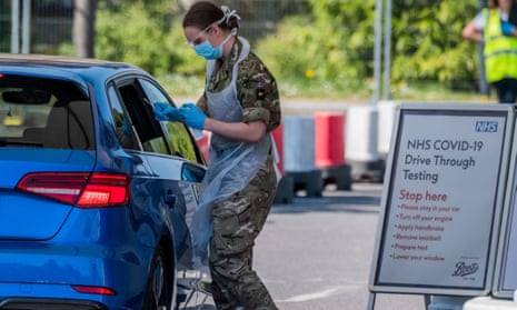 A soldier administers a coronavirus test to a car passenger