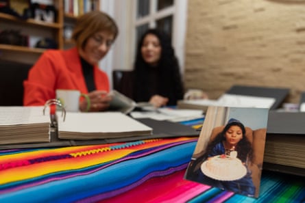 Sala and Nada sit together; in front of them is a small photo of Nada blowing out a candle on her seventh birthday