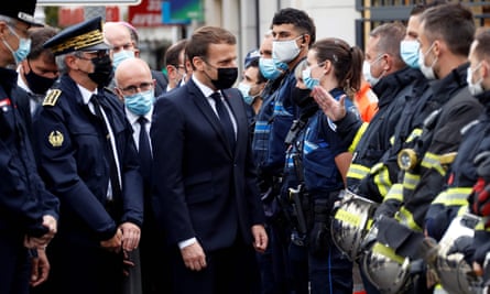 Emmanuel Macron (4th-L) talks to emergency workers at the scene of the attack.