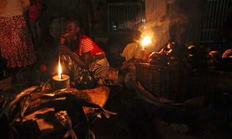 A woman sells fish by lantern light in Lagos, Nigeria. 