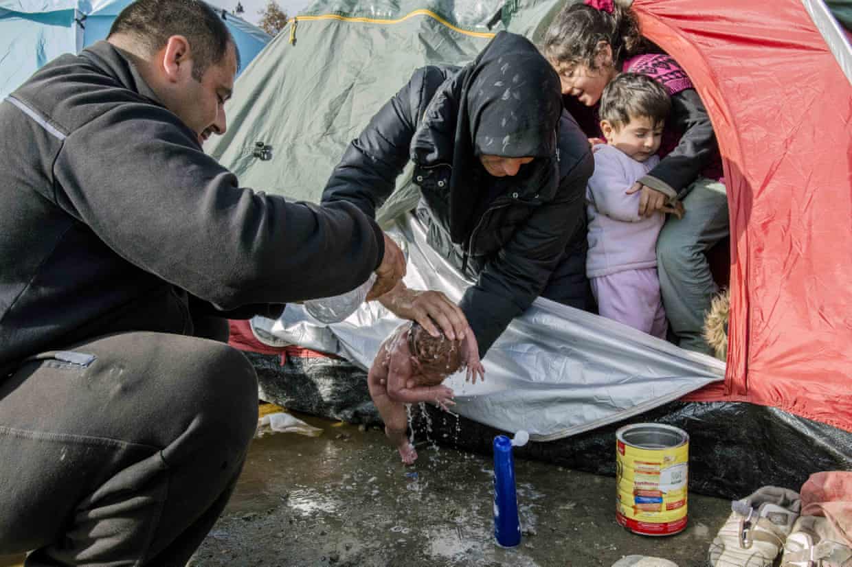 Refugees wash the baby born in a tent at the Idomeni refugee camp near the Greece-Macedonia border.