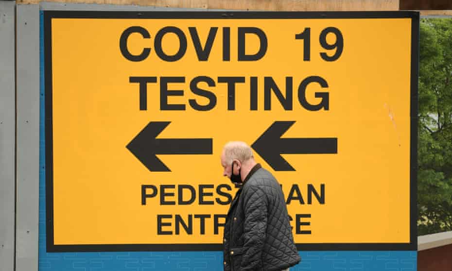 A man walks past a sign for a Covid-19 test centre
