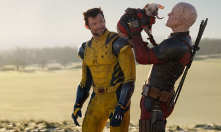 two people in super hero suits, one holding a dog