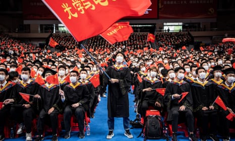Chinese students from Huazhong University of Science and Technology wave flags during a graduation ceremony