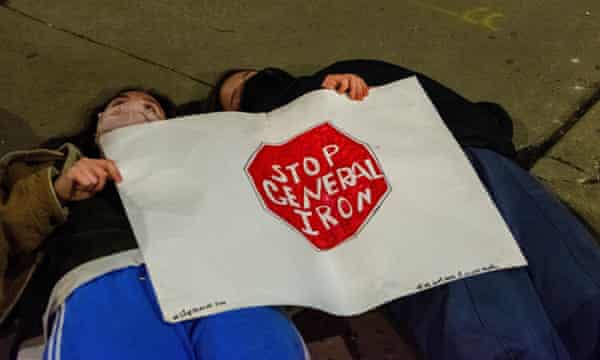 Chicago activists lie on the street as part of Thursday’s protest. Their sign reads ‘Stop General Iron’, referring to the metal shredder on the North Side that closed last year.