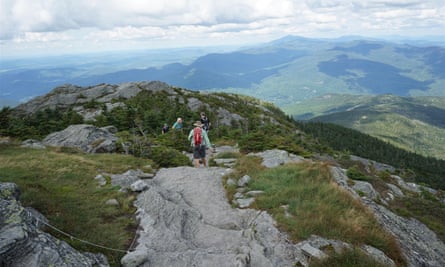Hiker beginning to descend the summit of Camels Hump in Huntington, Vermont US.