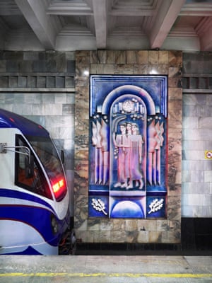 A ceramic mural is revealed as a train rolls out of Tashkent station