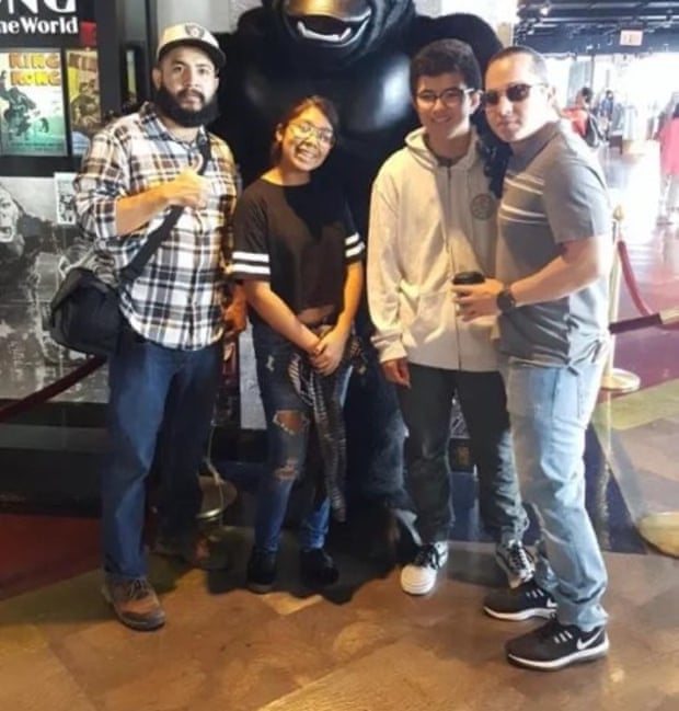 A group of people posing in front of a large gorilla-like figure