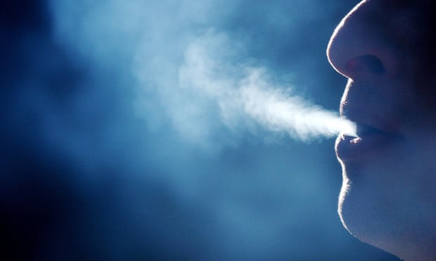 A stock image of a person breathing out smoke