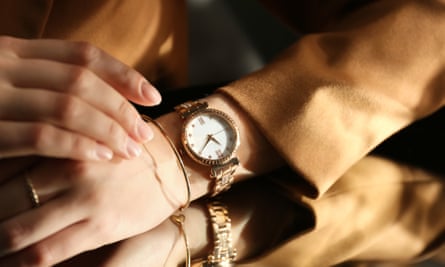 Woman wearing luxury wristwatch near mirror, closeup
