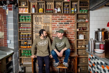 two men smiles while wearing hoodies that read ‘shouk’