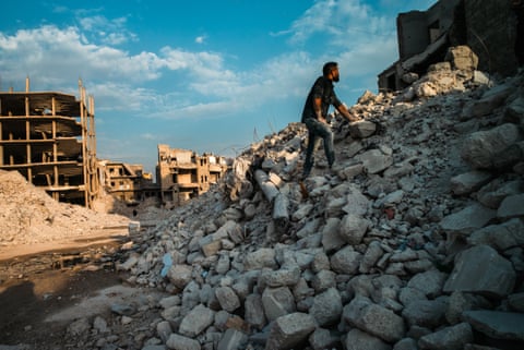 A man collecting stones from the rubble to use again, Amiriya district, Aleppo.