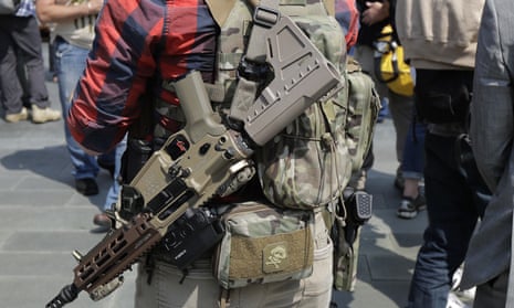 A man standing with members of Patriot Prayer and other groups supporting gun rights wears guns during a rally in Seattle. Patriot Prayer is a source of disagreement between leftwing and rightwing pro-gun groups.