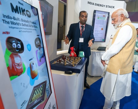A man who is looking at Modi's chess board is explaining something to him