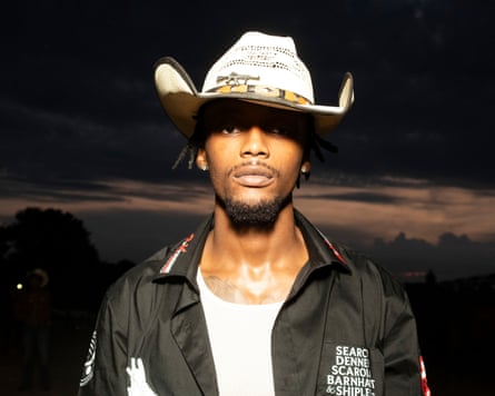 A man in a cowboy hat at night