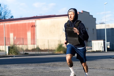 a man runs outside with a weighted vest