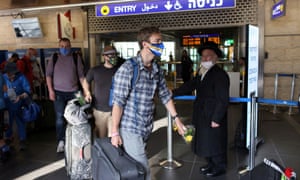 Coronavirus live: UK sees daily cases rise to over 50,000; WHO warns indoor socialising driving infections | World news 8 Tourists walk through the Ben Gurion international airport.