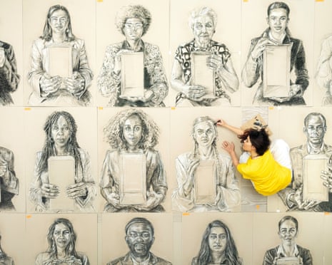 Es Devlin seated on the floor working on several portraits at once