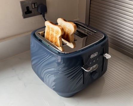 A DeLonghi Ballerina Seta 4 Slot Toaster with two slices of toast sticking out of it