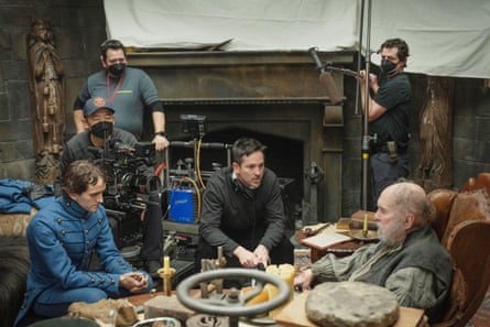 From left, front, Harry Melling as Edgar Allan Poe, cinematographer Masanobu Takayanagi, director Scott Cooper and Robert Duvall, on set for The Pale Blue Eye in 2022.