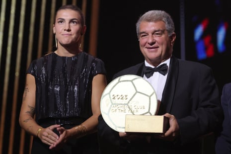 Barcelona's president Joan Laporta (right) and midfielder Patricia Guijarro (left) react on stage as Barcelona receives the Women's Club of the Year trophy during the 2023 Ballon d'Or ceremony.