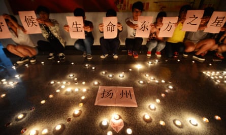 Students light candles and pray for victims of the Eastern Star at a Yangzhou college on Wednesday.