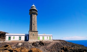 The Orchilla lighthouse on black volcanic rock, ocean in background