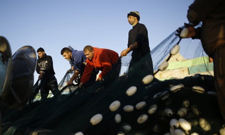 Palestinian fishermen prepare their net at the port in Gaza City