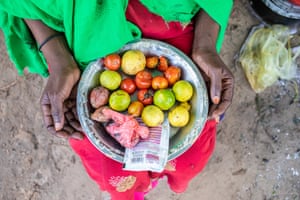 A woman holds a dish of food supplies at her makeshift home in the Xidig IDP camp in Mogadishu.