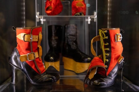 A pair of high-heeled, eight-eyed black leather boots with red material uppers, buckles and laces
