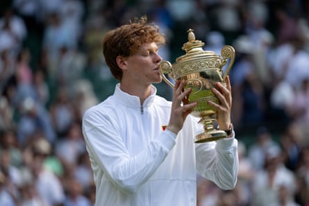 Jannik Sinner kissing his Wimbledon trophy.