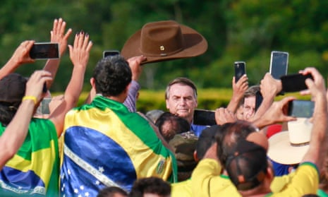 Jair Bolsonaro (centre) looks to his supporters in December, after losing the presidential election.  