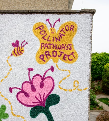 A mural of a butterly above a flower with the words ‘pollinator pathways project’ on its wings