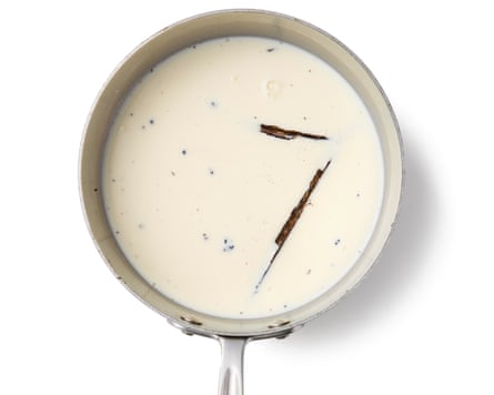 Pale liquid in a saucepan with two vanilla pods partially submerged