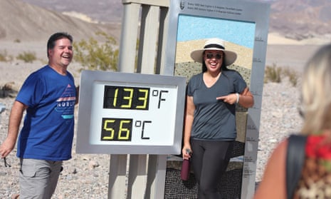 Dos turistas posan para una foto junto a una pantalla digital de una lectura de calor no oficial en el Centro de visitantes de Furnace Creek en Death Valley el domingo.