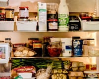 Refrigerator shelves packed with jars, sauces, dairy products, eggs, and fresh vegetables