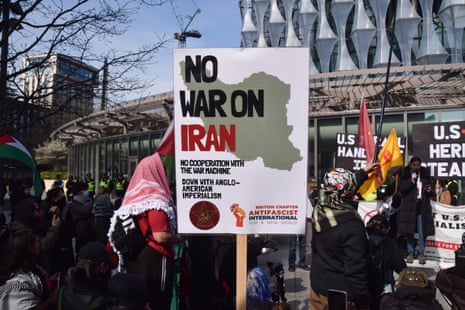 A protester holds a 'No war on Iran' placard during a demonstration outside the Embassy of USA, London, England, United Kingdom - 22 March 2026