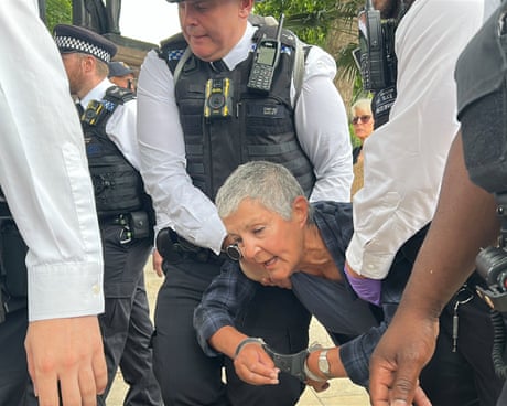 Officers carry a handcuffed woman from a protest in Parliament Square.