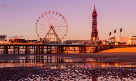 Blackpool Tower and Central Pier with reflection in water on beach at sunset, Lancashire, UK.