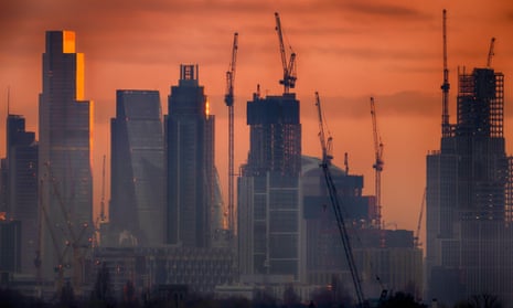 Skyline of City of London skyscrapers at daybreak, with an orange dawn glow behind them