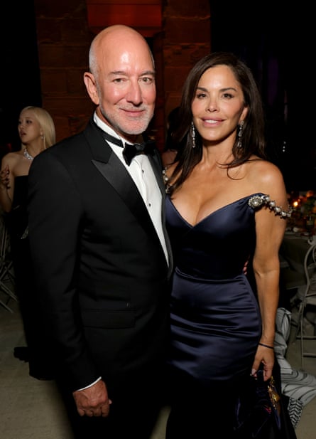 A man and a woman in black-tie dress pose for a picture
