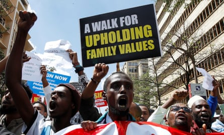 Angry-looking young black men shouting and waving placards, the most prominent saying a 'walk for upholding family values' 