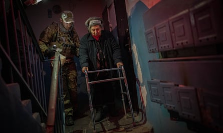 An elderly resident is evacuated from a building in Kherson on 27 November.