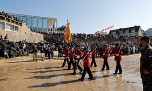 Netherlands’ troops march in red jackets on the beach at Arromanches-les-Bains