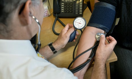 A GP checks blood pressure.